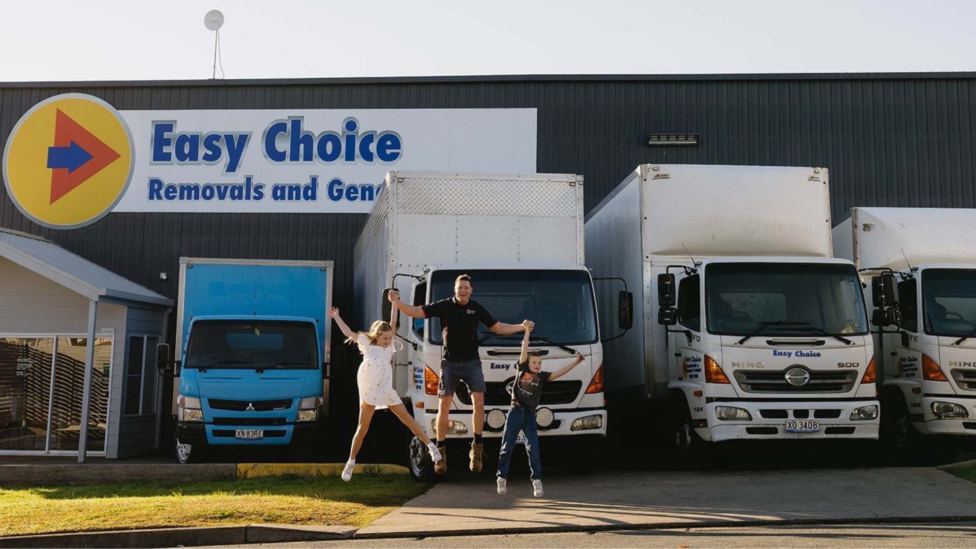 Rhys Purcell and family outside the Easy Choice Removals depot with the full fleet